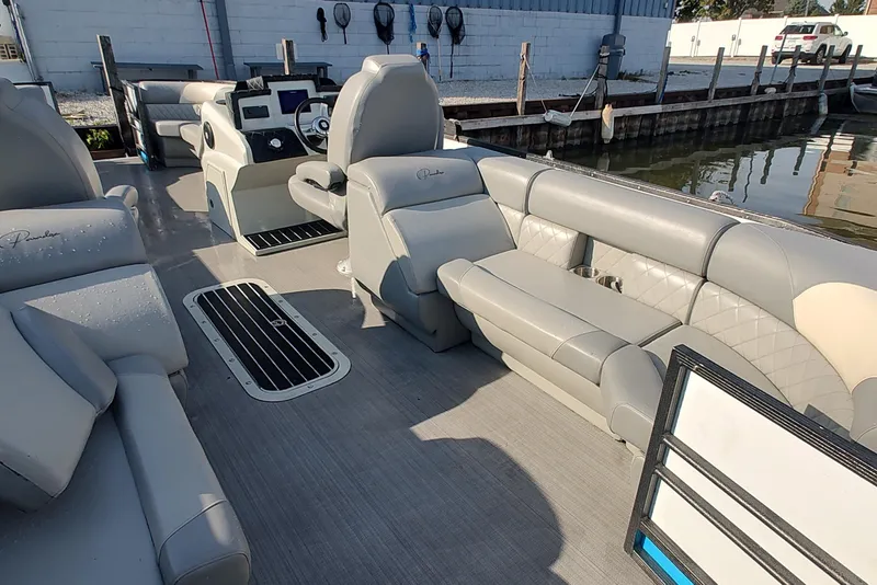 Slide: The Image of 2023 Paradise Pontoon Tritoon with luxurious seating and modern helm, docked by the water. - 3