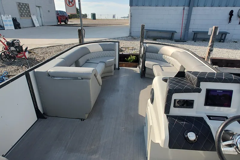 Slide: The Image of 2023 Paradise Pontoon Tritoon with luxurious seating and modern dashboard, docked at marina. - 6