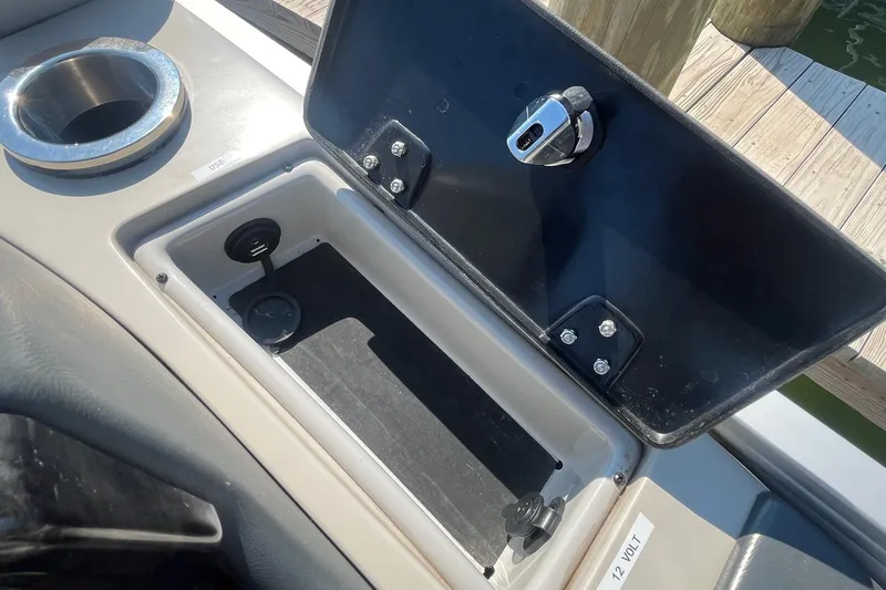 Slide: The Image of SunCatcher Elite 326C 2022 boat storage compartment with USB and 12V outlets. - 13