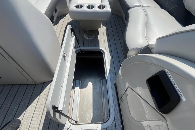 Slide: The Image of 2022 SunCatcher Elite 326C boat interior with open storage compartment and seating area. - 14