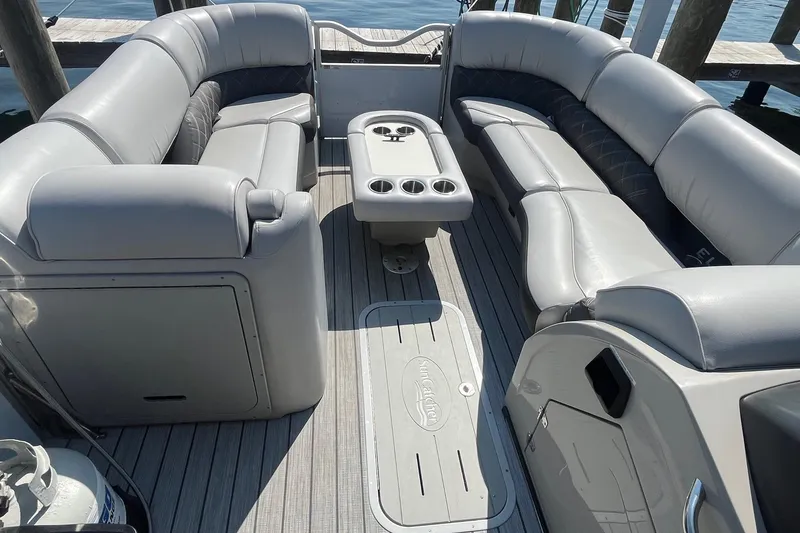 Slide: The Image of 2022 SunCatcher Elite 326C pontoon boat interior with plush seating and central table. - 15