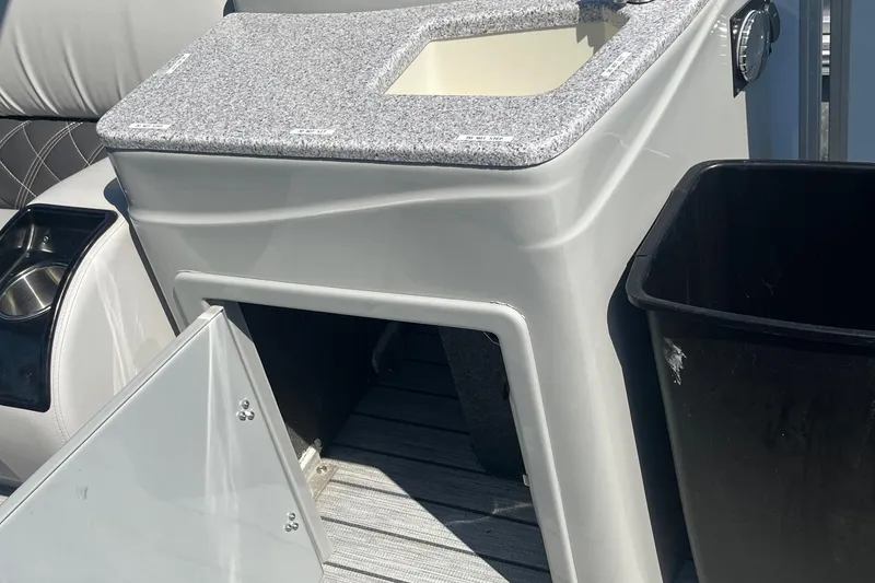 Slide: The Image of 2022 SunCatcher Elite 326C boat interior with storage compartment and cup holder. - 18
