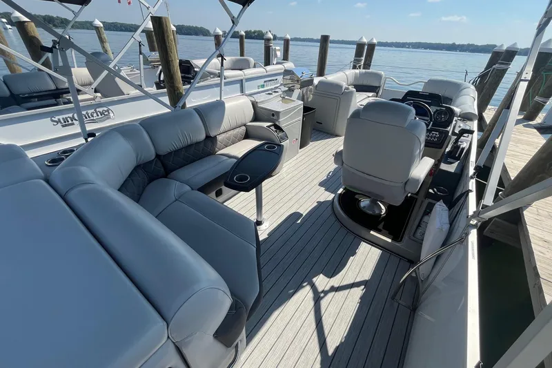 Slide: The Image of 2022 SunCatcher Elite 326C pontoon boat interior with plush seating and helm. - 6
