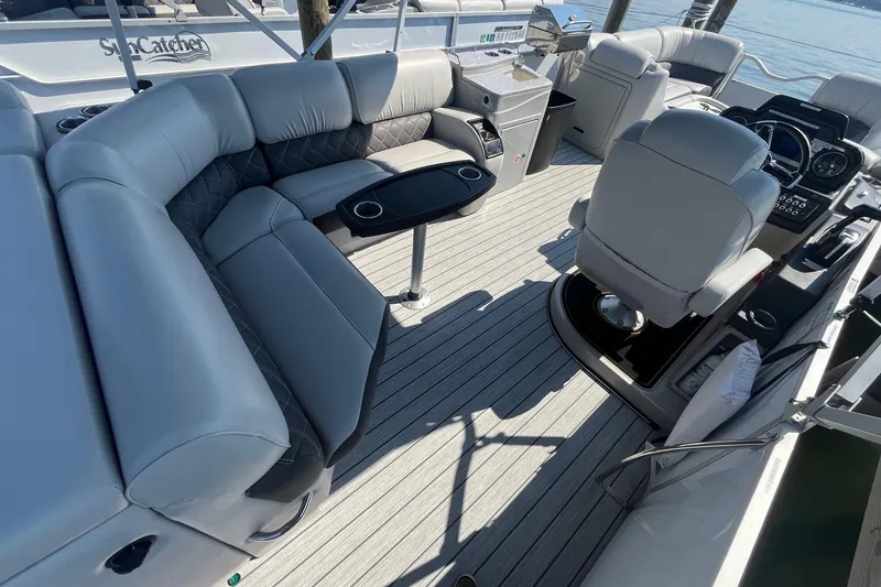 Slide: The Image of Luxurious interior of 2022 SunCatcher Elite 326C pontoon boat with plush seating and modern helm. - 7
