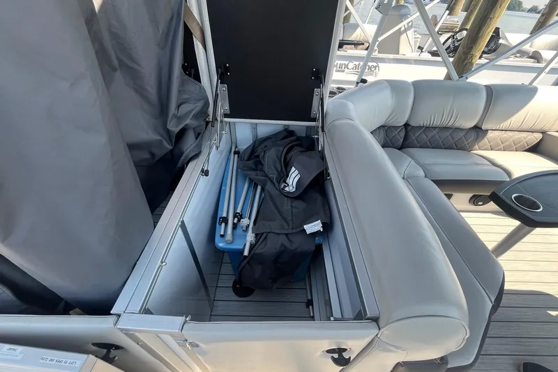 Slide: The Image of 2022 SunCatcher Elite 326C pontoon boat with open storage compartment and seating area. - 9