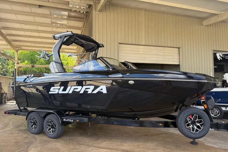 The Image of 2026 Supra SA 450 boat on trailer in covered storage area. - 0