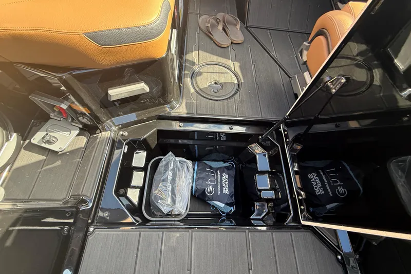 Slide: The Image of 2026 Supra SA 450 boat interior storage with bags and sandals on deck. - 10