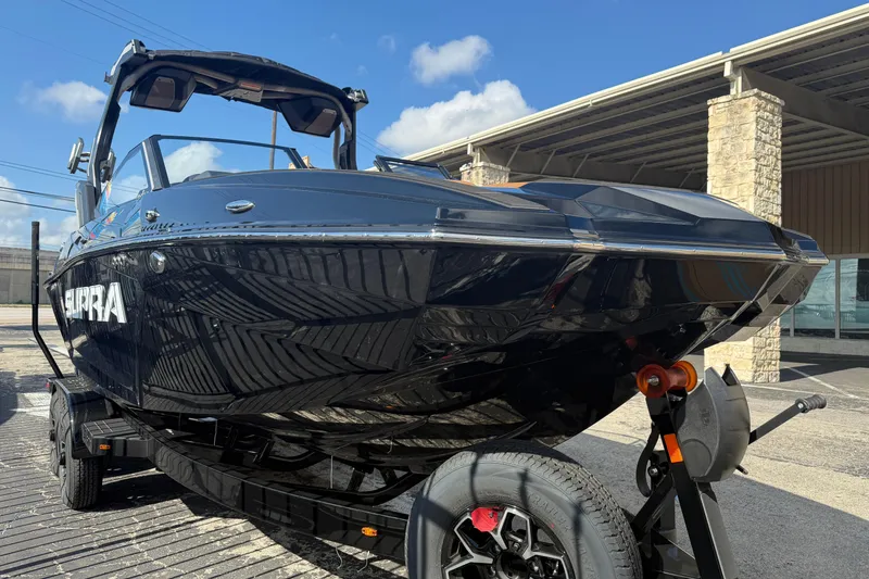 Slide: The Image of 2026 Supra SA 450 boat on trailer, sleek black design under clear blue sky. - 4