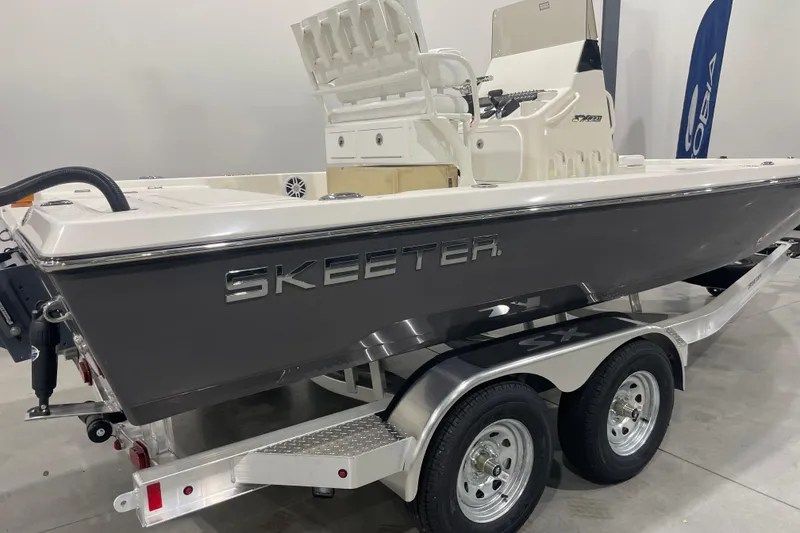 Slide: The Image of 2026 Skeeter SX221 boat on trailer, displayed indoors with sleek design. - 1