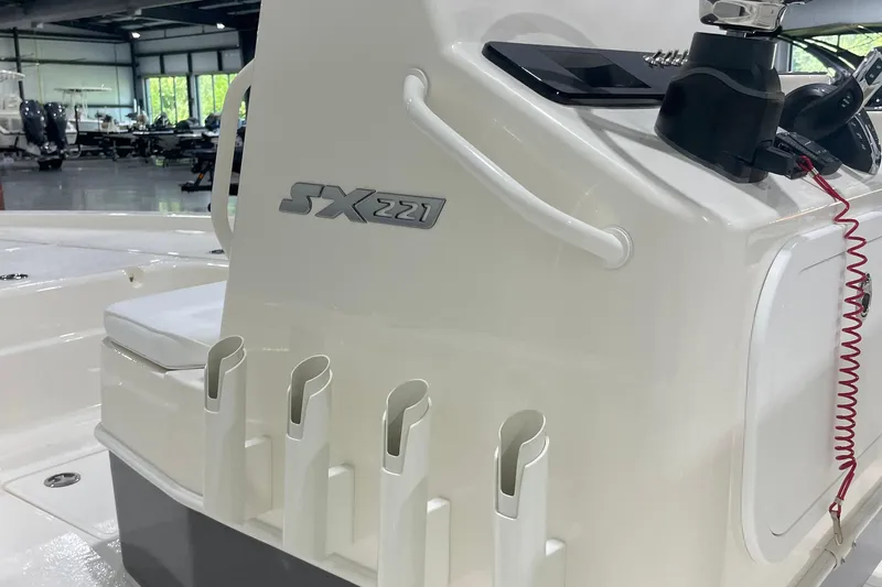 Slide: The Image of 2026 Skeeter SX221 boat interior with rod holders and control panel in a showroom. - 9
