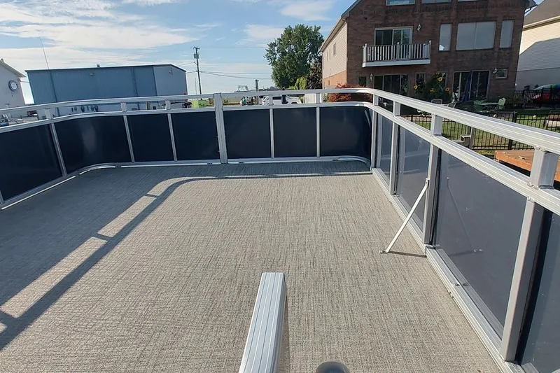 Slide: The Image of 2023 Tahoe Pontoon Cascade Funship deck with railing, in a residential area. - 4