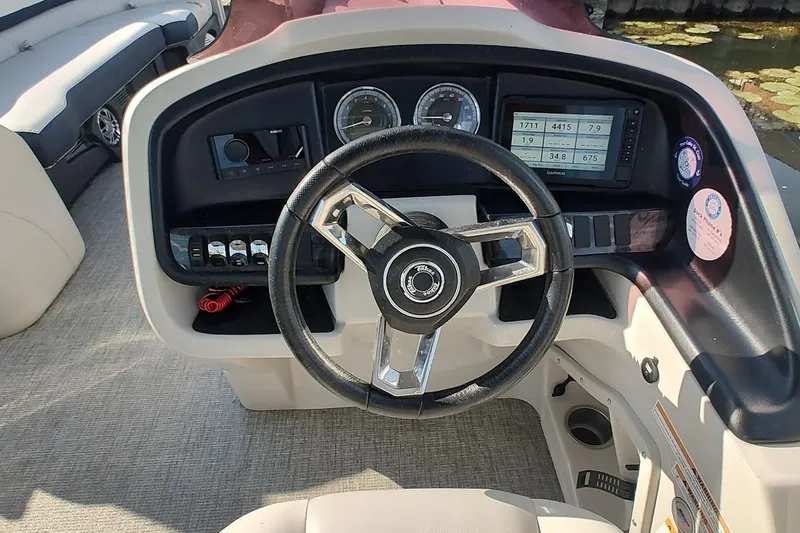 Slide: The Image of 2023 Tahoe Pontoon Cascade Funship dashboard with steering wheel and control panel. - 8