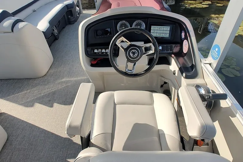 Slide: The Image of 2023 Tahoe Pontoon Cascade Funship helm with modern controls and comfortable seating. - 9