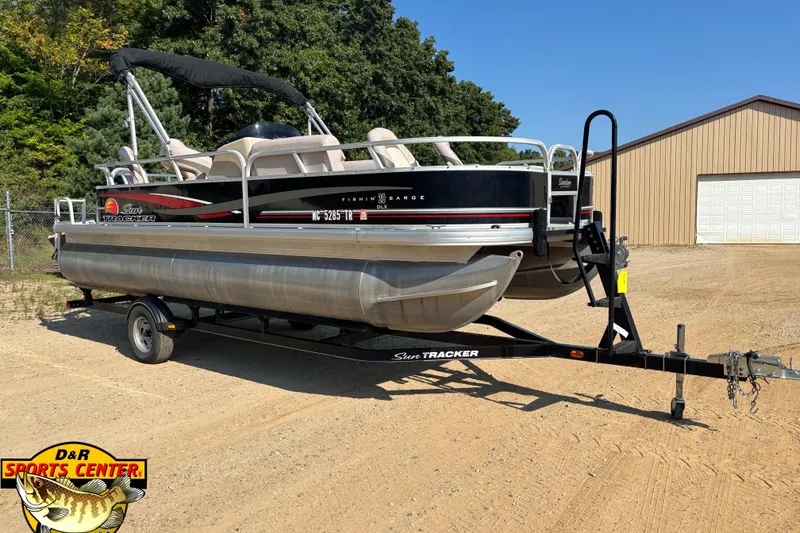 The Image of 2014 Sun Tracker Fishin' Barge 20 DLX pontoon boat on trailer, parked outdoors. - 0