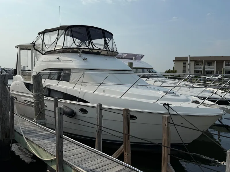 Slide: The Image of 2005 Meridian 459 Motoryacht docked at marina, featuring sleek design and spacious upper deck. - 0