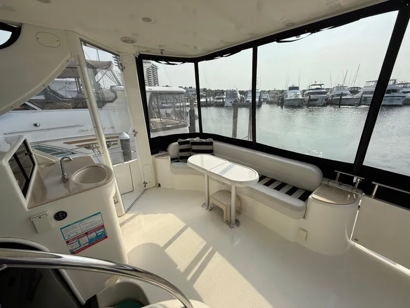 Slide: The Image of 2005 Meridian 459 Motoryacht interior with seating, table, and marina view. - 12
