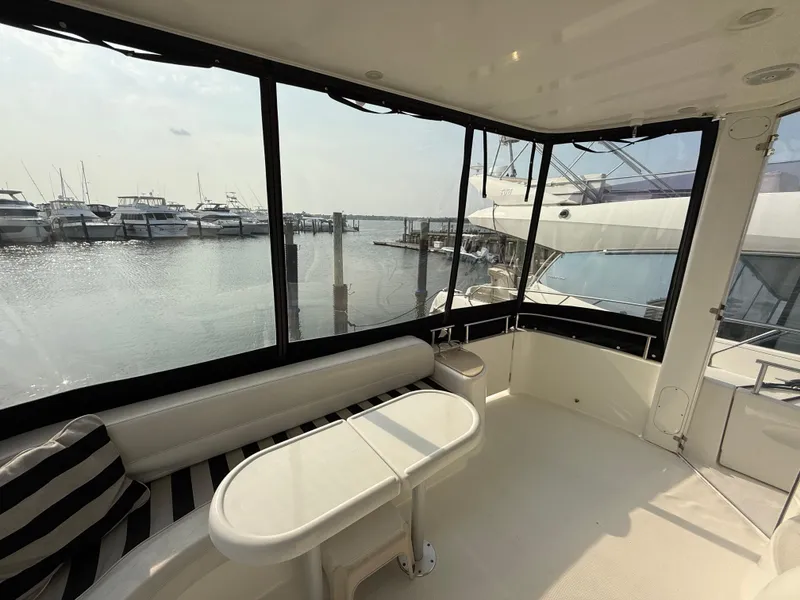 Slide: The Image of 2005 Meridian 459 Motoryacht interior with marina view, featuring seating and table. - 13