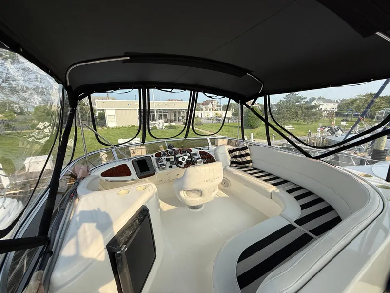 Slide: The Image of 2005 Meridian 459 Motoryacht cockpit with striped seating and helm controls. - 16