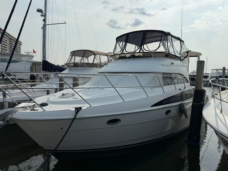 Slide: The Image of 2005 Meridian 459 Motoryacht docked at marina, featuring sleek design and spacious upper deck. - 3