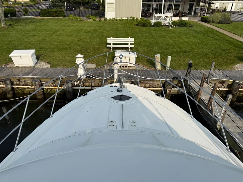 Slide: The Image of 2005 Meridian 459 Motoryacht docked, viewed from the bow, with grassy yard in background. - 5