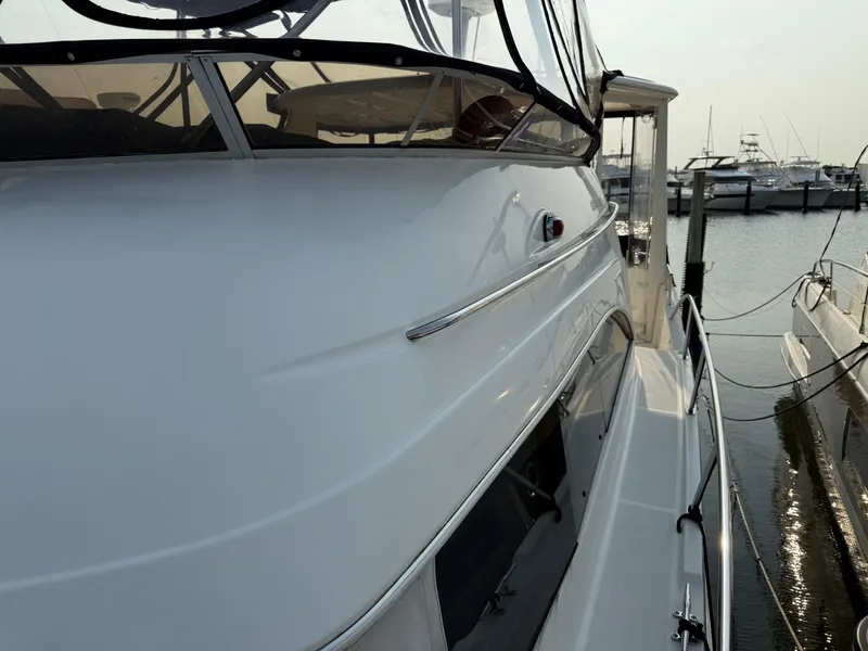 Slide: The Image of 2005 Meridian 459 Motoryacht docked at marina, showcasing sleek design and spacious deck. - 7