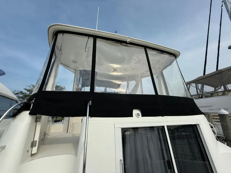 Slide: The Image of 2005 Meridian 459 Motoryacht with enclosed flybridge, docked under clear blue sky. - 9