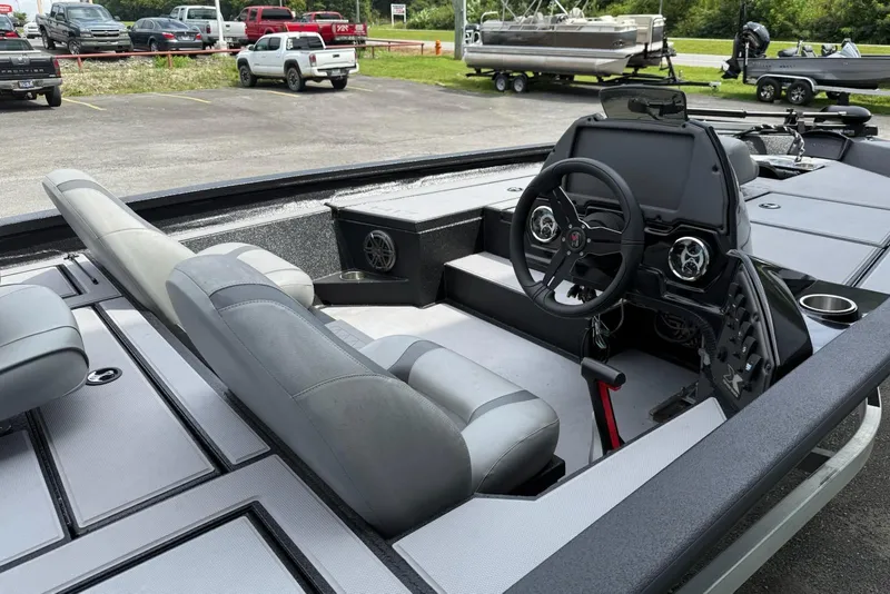 Slide: The Image of 2023 Xpress H17 boat interior with steering wheel and seating in a parking lot. - 7