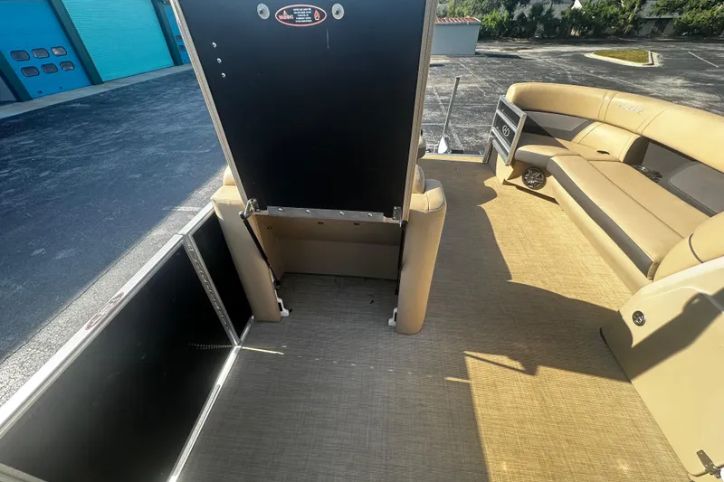 Slide: The Image of 2022 Harris Cruiser 230 interior with beige seating and open storage compartment. - 6