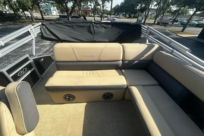 Slide: The Image of 2022 Harris Cruiser 230 boat interior with beige seating and speaker system. - 8