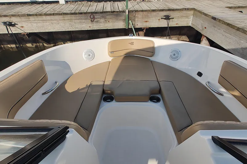 Slide: The Image of 2024 Bayliner VR6 Bowrider OB interior with tan seating and cup holders. - 12