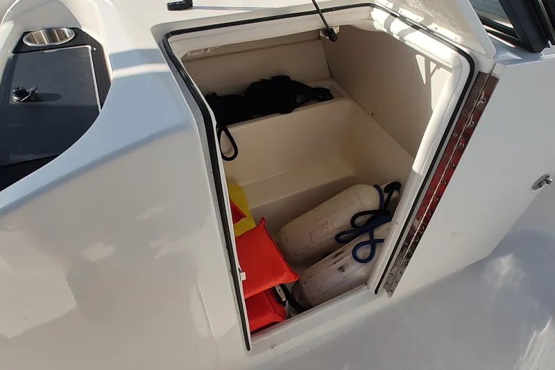 Slide: The Image of 2024 Bayliner VR6 Bowrider OB storage compartment with life jackets and fenders. - 13
