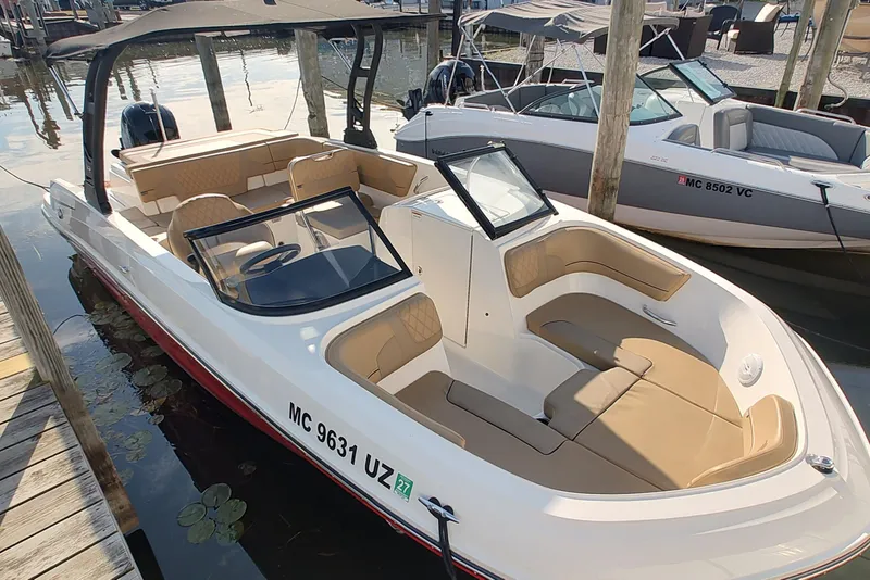 Slide: The Image of 2024 Bayliner VR6 Bowrider OB with tan seating, docked at marina. - 2