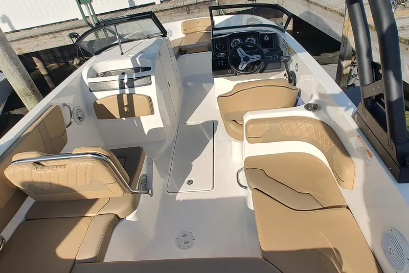 Slide: The Image of 2024 Bayliner VR6 Bowrider OB interior with tan seating and modern dashboard design. - 9