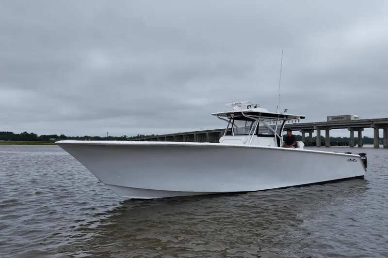 Slide: The Image of 2015 SeaHunter 45 Tournament boat on water near a bridge under cloudy skies. - 11
