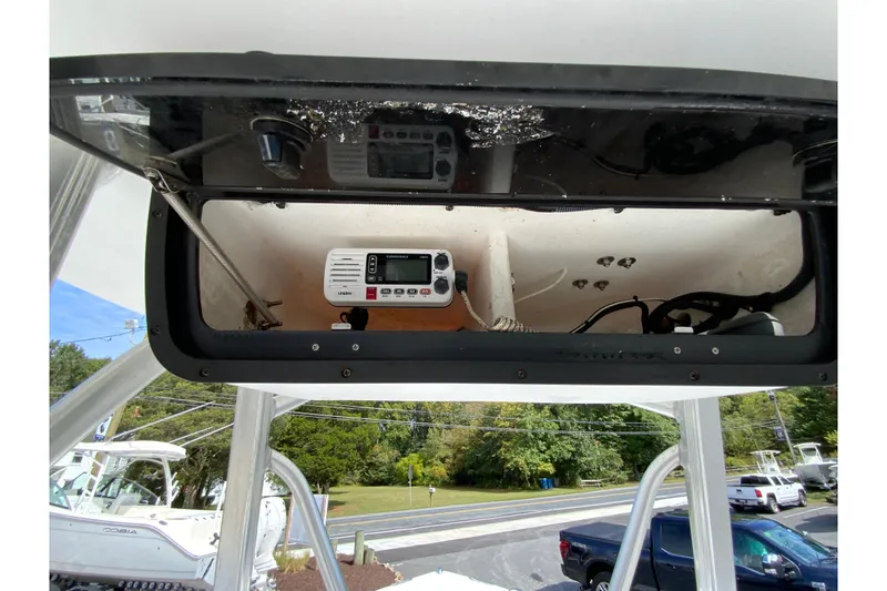 Slide: The Image of 2008 Sea Hunt Triton 220 boat console with radio equipment and storage compartment. - 24