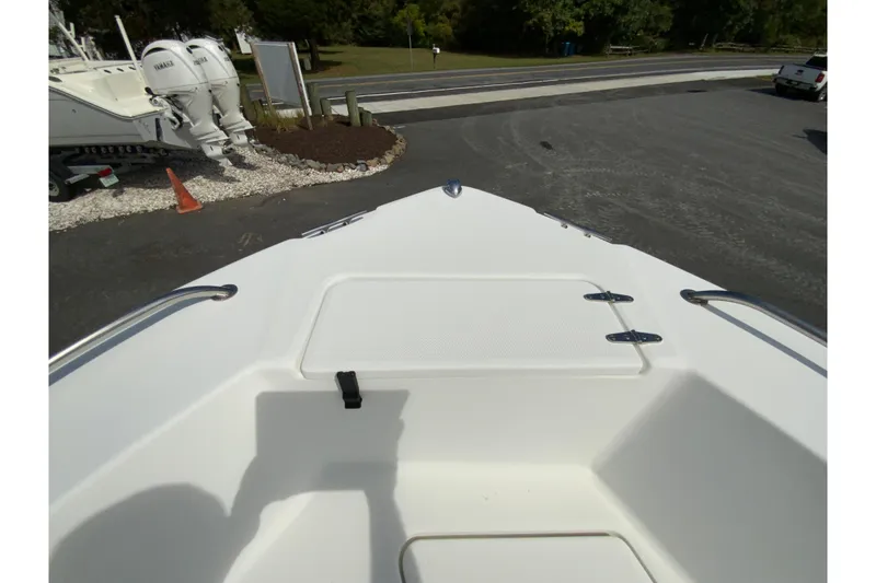 Slide: The Image of 2008 Sea Hunt Triton 220 boat deck with storage compartment, parked near outboard motors. - 27