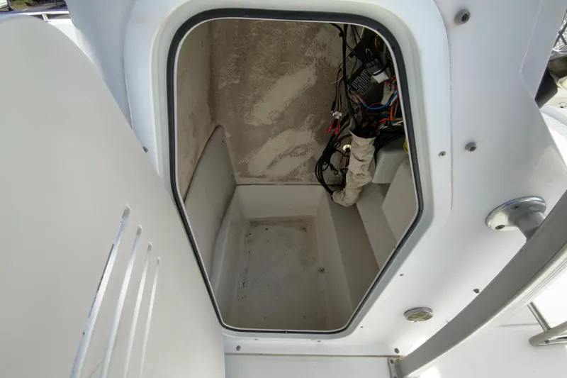 Slide: The Image of 2008 Sea Hunt Triton 220 storage compartment with visible wiring and clean interior. - 31