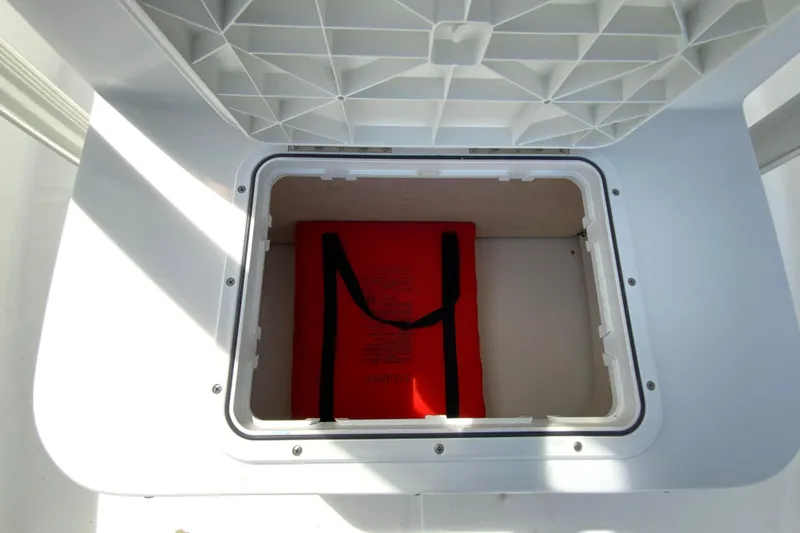 Slide: The Image of Storage compartment on a 2008 Sea Hunt Triton 220 boat with a red life jacket inside. - 33