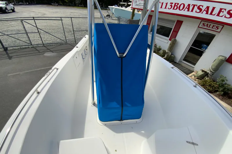 Slide: The Image of 2008 Sea Hunt Triton 220 boat interior with blue cover, displayed at a sales lot. - 34