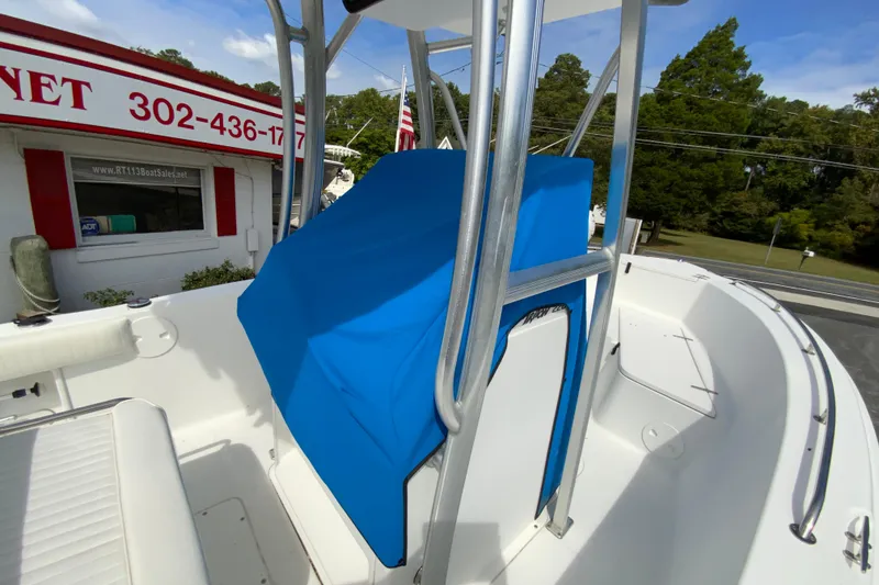 Slide: The Image of 2008 Sea Hunt Triton 220 boat with blue console cover, parked near a sales office. - 35