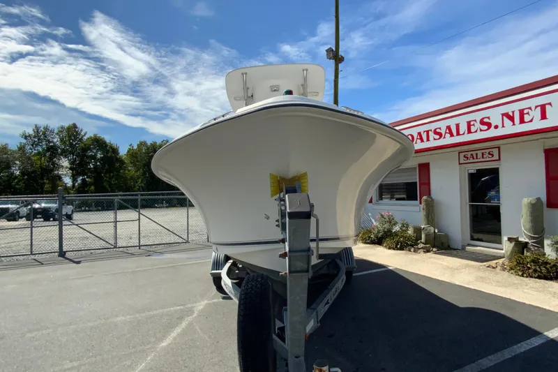 Slide: The Image of 2008 Sea Hunt Triton 220 boat on trailer outside dealership under blue sky. - 4