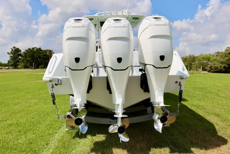 Slide: The Image of 2005 Venture 39 Open boat with triple outboard engines on grassy field. - 18