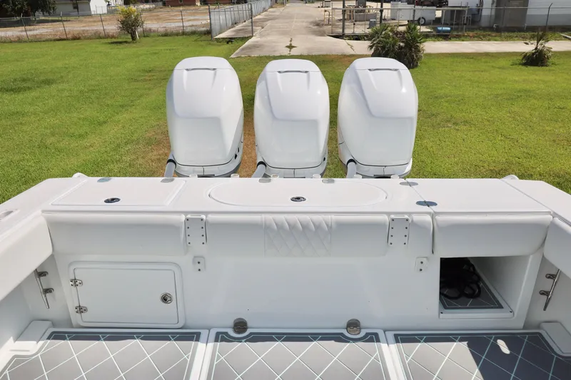 Slide: The Image of 2005 Venture 39 Open boat with triple outboard engines on grassy area. - 19