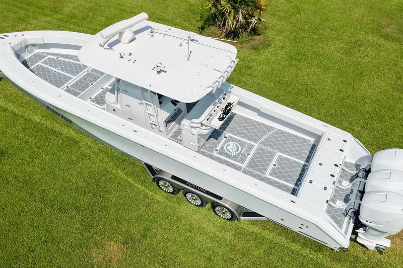 Slide: The Image of 2005 Venture 39 Open boat on grass, aerial view, showcasing sleek design and twin engines. - 2