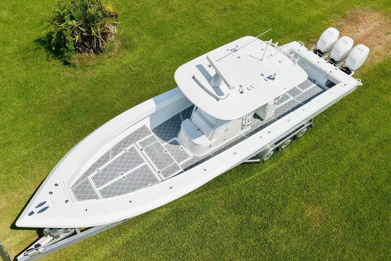Slide: The Image of Aerial view of 2005 Venture 39 Open boat on grass with triple outboard engines. - 3