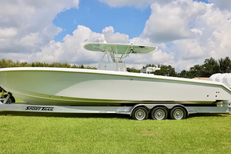 Slide: The Image of 2005 Venture 39 Open boat on Sport Trail trailer, parked on grass under a cloudy sky. - 6