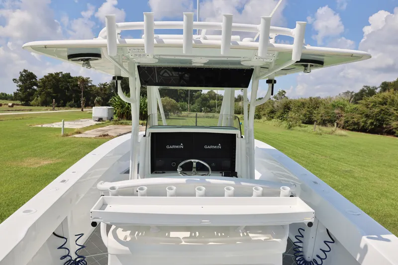 Slide: The Image of 2005 Venture 39 Open boat with Garmin electronics, docked on grassy area under blue sky. - 7