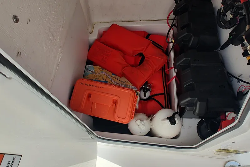Slide: The Image of Storage compartment of 2023 Twin Vee LFG 22 CC with life jackets and safety gear. - 10