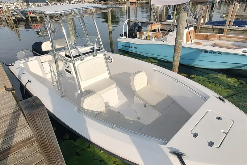 Slide: The Image of 2023 Twin Vee LFG 22 CC boat docked at marina, featuring spacious seating and sleek design. - 4