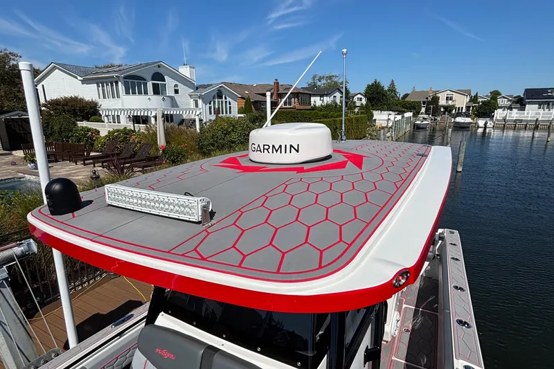 Slide: The Image of 2023 Fountain 34 SC boat with Garmin equipment, docked near waterfront homes. - 14